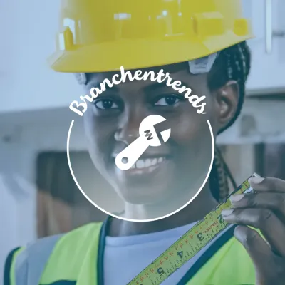 Eine lächelnde Baumeisterin in Schutzhelm und Sicherheitsweste misst mit einer Maßband.